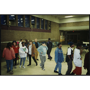 A group of youth walk around a room at a Tri-Club event