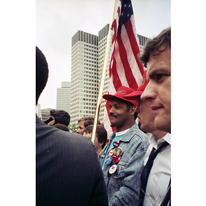 Rainbow Coalition leader Jesse Jackson holding the American flag at the NYNEX workers' strike and rally at City Hall Plaza, Boston