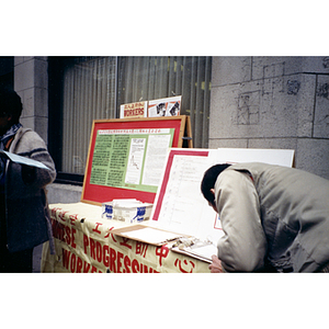 Chinatown resident signs an unemployment insurance reform petition