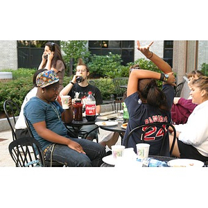 Several Torch Scholars sit with beverages at the Question and Answer Pizza Party