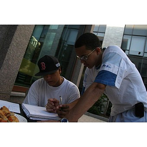 Danny Vazquez and Odalis David Polanco look at papers at the Torch Scholars Question and Answer Pizza Party