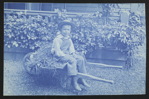 Boy on a wheelbarrow, location unknown, July 1897