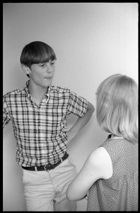 Teenage long hair: teenage boy leaning against a wall, talking to a girl