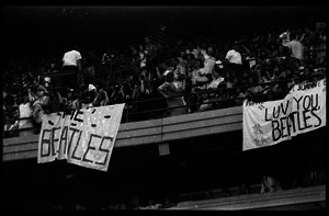 Beatles concert at Shea Stadium: fans packed into the upper deck of the stadium before the concert with banners reading 'The Beatles' and 'Luv you Beatles'