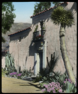 California: cactus and other desert plantings in front of a pink stucco Spanish colonial-style house