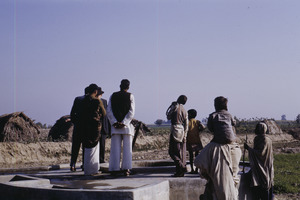 Group of villagers around a concrete construction
