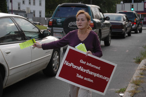 Protest against a pornographic video store in Northampton: protester with sign 'NoPornNorthampton.org,' handing out fliers to cars on North Street