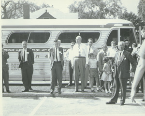 Alumni Medal recipients and family stand in front of a bus during Centennial Alumni weekend