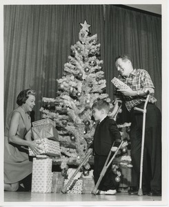 Mrs. Kilbourne with clients in front of Christmas tree