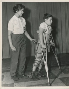 Arnold Goldman practices walking with his two leg braces and crutches