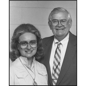 Man and woman posing together, both wearing glasses