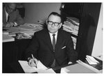 Suffolk University Professor Dion J. Archon (CAS) seated behind desk, photograph, circa 1960s
