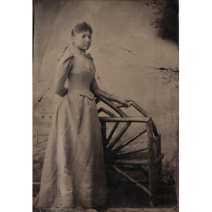 An African American woman standing by a wooden bench
