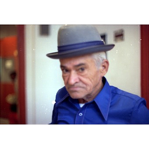 An elderly man, wearing a blue shirt, participates in a program at La Alianza Hispana, Boston.