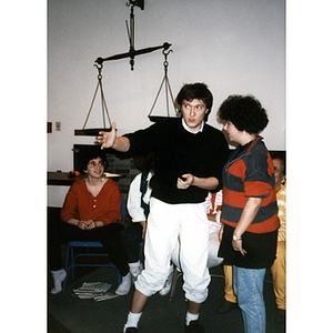 Claudio Ragazzi gesturing and talking with a woman at a staff retreat while other staff members look on.