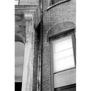 Detail of a bay window and a door surround on a brick row house.