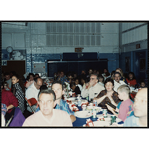 Children and adults, seated together, look to the front during a Kiwanis Awards Night