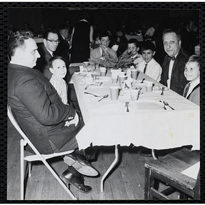 Men and boys pose at a table during a Dad's Club banquet