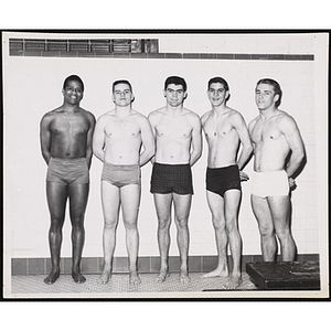 Five teenage boys pose for a group shot in a natatorium