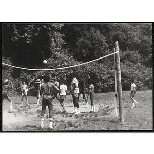 A Group of youth playing volleyball in a field