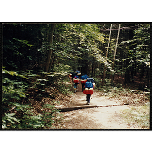 A group of youth with backpacks hike along the Piper Trail