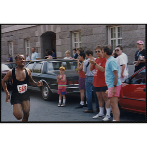 A man runs past cheering spectators during the Bunker Hill Road Race