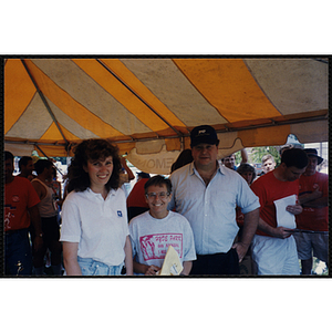 A runner poses with a woman and man during the Bunker Hill Road Race