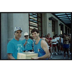 A man receives a gift box from another man at the Battle of Bunker Hill Road Race