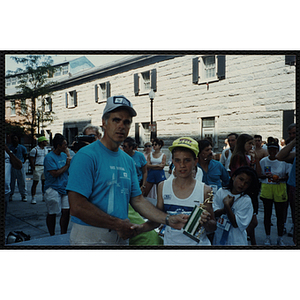 A man hands a boy a trophy as they shake hands at the Battle of Bunker Hill Road Race