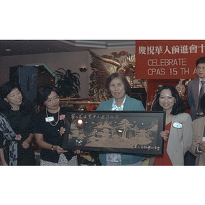 Suzanne Lee and others with artwork at Chinese Progressive Association's 15th Anniversary Celebration