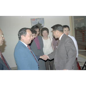 Member of the Consulate General of the People's Republic of China shakes hands with attendees at a welcome party held for the Consulate General's visit to Boston