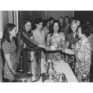 Junior nursing students serving tea to seniors from the first Bachelor of Science graduating class