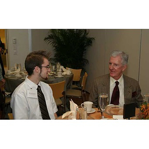 Jordan Munson speaks with a man at the Torch Scholars dinner