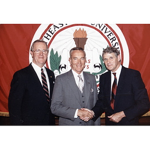 Chairman of the Board of Trustees George J. Matthews (left), Corporation member William Downey (center), and Northeastern President John Curry