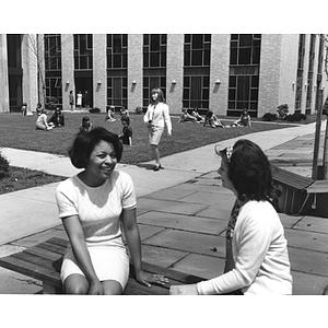 Female students sit on a bench outside Speare Hall