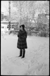 Woman in a heavy fur coat standing outside after a heavy snow