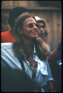 Smiling audience member in round glasses at the Woodstock Festival