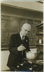 Walter W. Chenoweth stirring a pot on stove, in laboratory