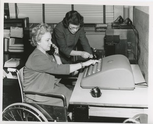 Mrs. Frances Marsala seated in her wheelchair operating a machine for a telephone answering service