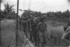 Captain Chinh followed by Horner returning from operation; Saigon.