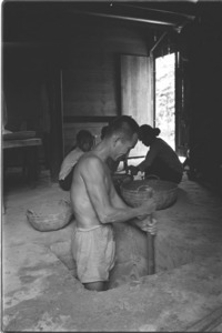 Farmer digging a family shelter on the floor of his home as protection against bombing; Tay Ninh.