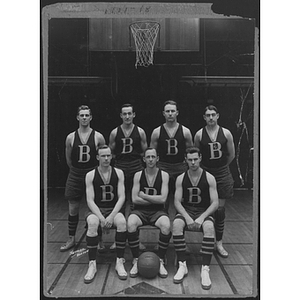 Group portrait of young men's basketball team in front of hoop