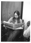 A Suffolk University student reads "Time Out" in the recreation hall, photograph, circa 1970s