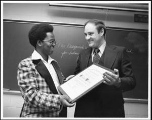 Timothy Whelan accepting an award from Mohamed Barrie of the International Student Association, 11/1977