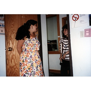 Two female Inquilinos Boricuas en Acción staff members talking to each other as they stand in an open doorway in the office.