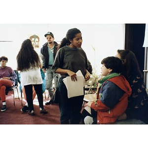 Unidentified Inquilinos Boricuas en Acción staff member talking with a woman and child at a community meeting in the Inquilinos Boricuas en Acción offices.