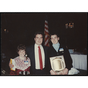 Julie Treanor and Jason Gallagher holding their awards and posing with an unidentified man at the "Recognition Dinner at Harvard Club"