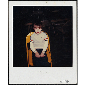 A boy from the Boys and Girls Clubs of Boston sitting in a yellow chair