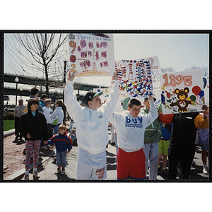 Several boys holding up their signs during the Boys and Girls Clubs of Boston 100th Anniversary Celebration Parade