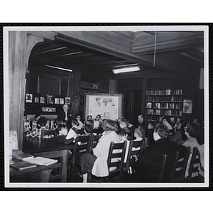 Boys and adults gather in the reading room of a library